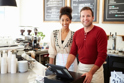 A Young Couple, Own their Own Coffee Shop Smile at Camera